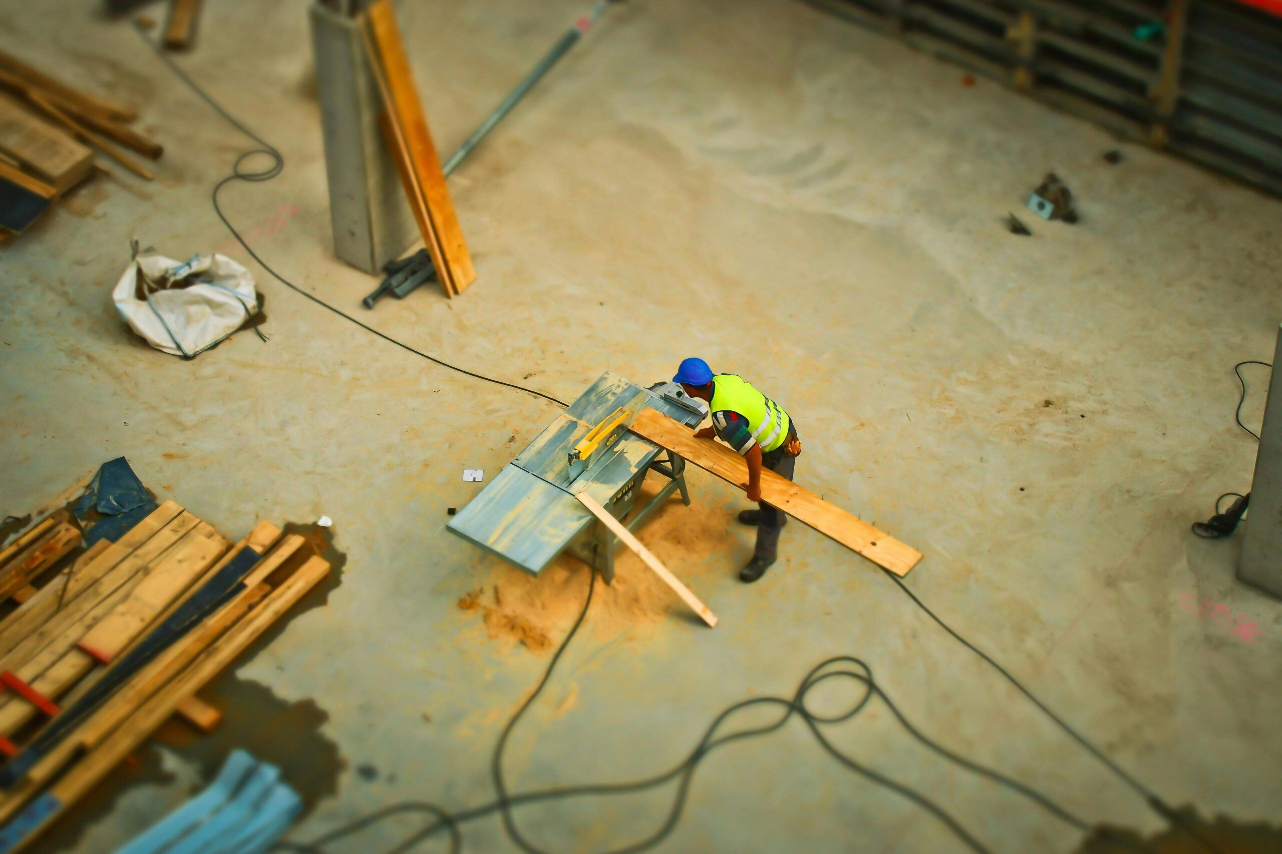 person-cutting-wood-on-table-saw-during-daytime